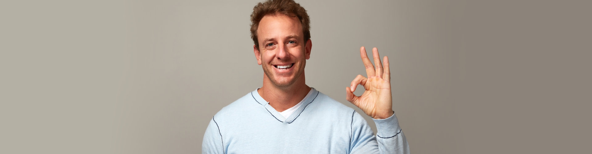 adult man smiling with okay hand sign