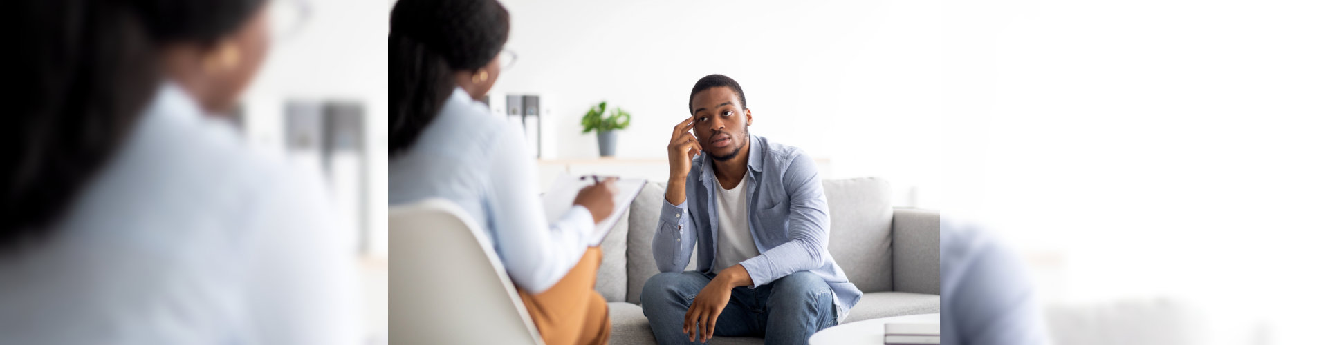 Stressed black man suffering from depression, counselor providing professional assistance at medical office